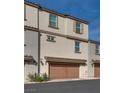 Three-story townhome with two car garage, neutral stucco, roof and doors at 538 Ylang Pl, Henderson, NV 89015