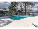 Community pool with clear blue water, surrounded by a concrete patio and fencing, near mature trees at 5523 Orchard Ln # 0, Las Vegas, NV 89110