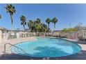 Community pool surrounded by palm trees and lounge chairs, perfect for relaxation and enjoying the outdoors at 5552 Dueces Wild Ct # 101, Las Vegas, NV 89122
