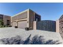 A long paver driveway leads up to the three car garage and gate for this single story home at 6845 Hidden Sunset Ln, Las Vegas, NV 89120