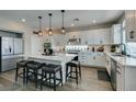 Well-appointed kitchen featuring an island with barstool seating, stainless steel appliances, and white cabinetry at 7077 Sunland Hills Ave, Las Vegas, NV 89113