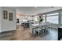 Bright, modern kitchen with white cabinets, large island, and adjacent dining area with seating for eight at 7077 Sunland Hills Ave, Las Vegas, NV 89113