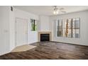 Bright living room featuring wood-look floors, a cozy fireplace, and large windows at 7143 S Durango Dr # 202, Las Vegas, NV 89113
