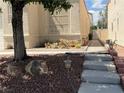 Quaint front yard with desert landscaping, pathway, and mature tree, leading to the home's entrance at 7620 Donald Nelson Ave, Las Vegas, NV 89131