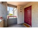 Apartment entrance with welcome mat, burgundy door, and unit number, providing a warm welcome at 8600 W Charleston Blvd # 2187, Las Vegas, NV 89117