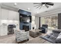Cozy living room with a fireplace, ceiling fan, sliding glass door to the patio, and modern furniture at 8941 Indigo Rose St, Las Vegas, NV 89166