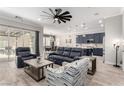 Open-concept living space with wood-look floors, a large sectional sofa, and a view of the kitchen at 8941 Indigo Rose St, Las Vegas, NV 89166