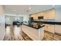 An open layout living room with a black countertop kitchen island, and a dark leather sofa at 9050 W Tropicana Ave # 1015, Las Vegas, NV 89147