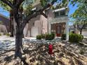 Inviting home exterior with a red door, stone landscaping, and a covered entrance at 9116 Vista Greens Way # 104, Las Vegas, NV 89134