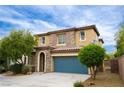 Charming two-story home featuring a tile roof, stone accents, and a blue two-car garage door at 9312 Poseidon Valley Ave, Las Vegas, NV 89178