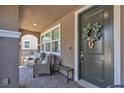 Inviting covered front porch with comfortable seating and a charming wreath on the front door at , Henderson, NV 89044