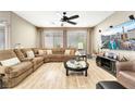 Large living room featuring a sectional sofa, ceiling fan, and a wall-mounted television at 10247 Jamapa Dr, Las Vegas, NV 89178