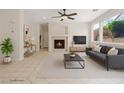 Comfortable living room featuring a cozy fireplace, neutral decor, and large windows for natural light at 10680 Sapphire Vista Ave, Las Vegas, NV 89144