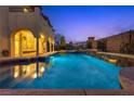 Inviting backyard pool and spa with tiered waterfalls and beautiful landscaping at twilight at 12021 La Palmera Ave, Las Vegas, NV 89138
