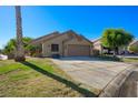 Single-story house boasting a well-maintained lawn, a two-car garage, and desert landscaping at 1441 Palm Dr, Laughlin, NV 89029