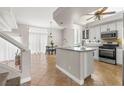 Bright kitchen featuring an island with seating, tile flooring, white cabinets, and stainless steel appliances at 2080 Silver Breeze Ave, Las Vegas, NV 89183