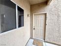 Condo front entrance featuring a beige door and a 