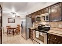 Galley kitchen with stainless steel appliances, dark cabinetry, and tile backsplash at 2725 S Nellis Blvd # 1037, Las Vegas, NV 89121