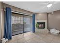Living room with fireplace, tile flooring, sliding glass doors to the outside patio and neutral colored walls at 2995 E Sunset Rd # 134, Las Vegas, NV 89120