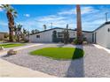 Landscaped front yard with green patches, desert plants and palm trees at 3647 Ottawa Cir, Las Vegas, NV 89169