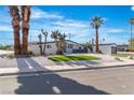 Contemporary home featuring desert landscaping with a circular driveway and palm trees set against a blue sky at 3647 Ottawa Cir, Las Vegas, NV 89169
