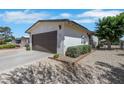 Close-up of a house exterior with a garage, xeriscaping, and partial fencing at 415 Emerald Cir, Henderson, NV 89002