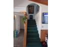 Carpeted staircase featuring wood railing, adjacent to kitchen and other rooms at 508 Tara Ct, Boulder City, NV 89005