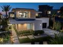 Modern home showcasing a unique design, lush landscaping, and a stylish driveway in a serene setting at 523 Overlook Rim Dr, Henderson, NV 89012