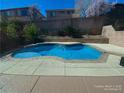 A refreshing backyard pool with a clean, modern design complemented by a concrete patio and lush landscaping at 533 Via Santiago St, Las Vegas, NV 89144