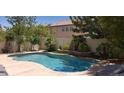Inviting pool surrounded by mature trees, green landscaping, and concrete decking at 5941 Alington Bend Dr, Las Vegas, NV 89139