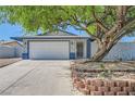 Inviting single-story home with a two-car garage, complemented by mature landscaping and blue accents at 6309 Miraloma St, Las Vegas, NV 89108