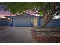 Inviting single-story home with a two-car garage, complemented by mature landscaping and colorful sky at 6309 Miraloma St, Las Vegas, NV 89108