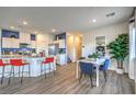 Open-concept kitchen boasts white cabinetry, stainless appliances, and a breakfast bar with seating at 7935 Pandora Sky St # 393, North Las Vegas, NV 89084