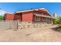 View of back of home with red siding and stone facade in backyard featuring desert landscaping at 812 Pyramid Dr, Las Vegas, NV 89107