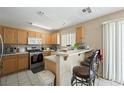 Well-lit kitchen featuring wood cabinets, stainless steel appliances, and a breakfast bar at 845 Bladensburg St, Las Vegas, NV 89110