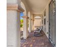 Inviting front porch with a tile floor, decorative columns, and comfortable seating for relaxation at 8925 Kenzie Cove St, Las Vegas, NV 89131