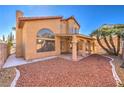 This home's backyard includes a covered patio and minimalist desert-style landscaping at 8932 Beach Front Dr, Las Vegas, NV 89117