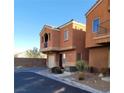 Two-story home with desert landscaping featuring a two-car garage and a small balcony at 9402 Crimson Sky St, Las Vegas, NV 89178