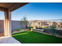 Backyard featuring artificial grass, a stone planter, and views of the surrounding community at 9476 Lunar Phase St, Las Vegas, NV 89143