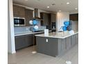 Beautiful kitchen with an island, gray cabinets, and stainless steel appliances at 9476 Lunar Phase St, Las Vegas, NV 89143