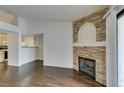 An open-concept living room featuring wood floors and a decorative stone fireplace at 950 Seven Hills Dr # 524, Henderson, NV 89052