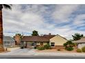 Charming single-story home with gated carport, desert landscaping, and mature palm tree at 1017 E Oakey Blvd, Las Vegas, NV 89104