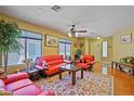Warm living room with large windows, hardwood floors, and cozy seating arrangements at 10203 Arlington Abby St, Las Vegas, NV 89183
