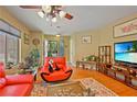 Bright living room featuring hardwood floors, a large window, and comfortable red seating at 10203 Arlington Abby St, Las Vegas, NV 89183