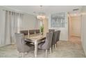 Elegant dining room featuring a stylish chandelier and a contemporary glass-top table with seating for eight at 1317 Hopespring Loop Ave, North Las Vegas, NV 89084
