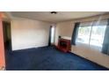 Spacious living room with blue carpets, a fireplace, and natural light from the window at 1701 E Katie Ave # 91, Las Vegas, NV 89119