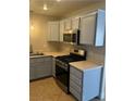 Well-lit kitchen features stainless steel appliances, light-blue cabinets, and tile floors at 2025 Cary Grant Ct, Las Vegas, NV 89142