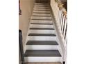 A view of the staircase with white railings and modern gray wood-look steps at 2025 Cary Grant Ct, Las Vegas, NV 89142