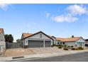 Inviting single-story home with a two-car garage, tiled roof, desert landscaping, and ample parking at 209 Tamarack Dr, Henderson, NV 89002
