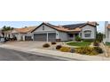 Attractive single-story house with a two-car garage, terracotta roof, solar panels, and manicured landscaping at 209 Tamarack Dr, Henderson, NV 89002